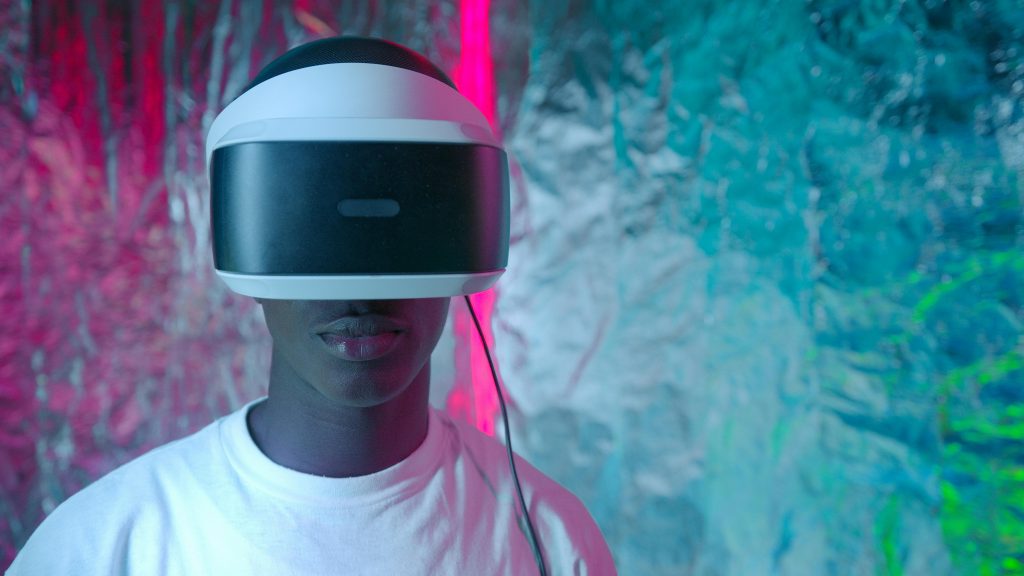 pexels-photo-7773547-7773547 Teen enjoying virtual reality experience with vibrant neon lights.